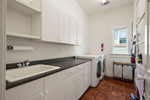 800 W Lynn St, Austin, TX 78703 - washroom featuring washer and clothes dryer, cabinet space, dark tile patterned floors, and baseboards