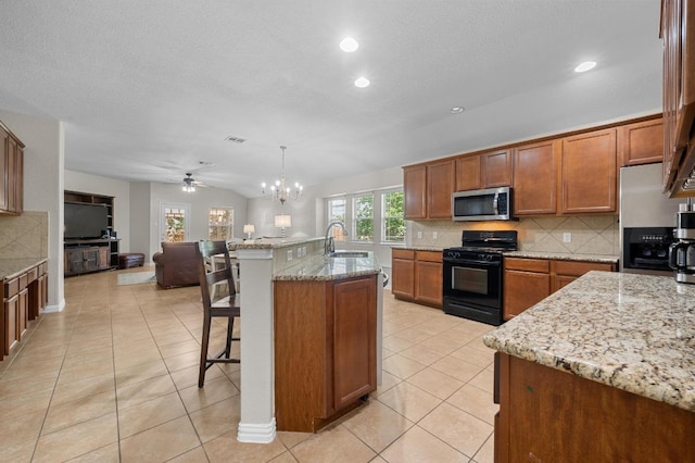 1286 Talley Loop, Buda, TX 78610 - kitchen featuring appliances with stainless steel finishes, tasteful backsplash, a breakfast bar, open floor plan, and a sink