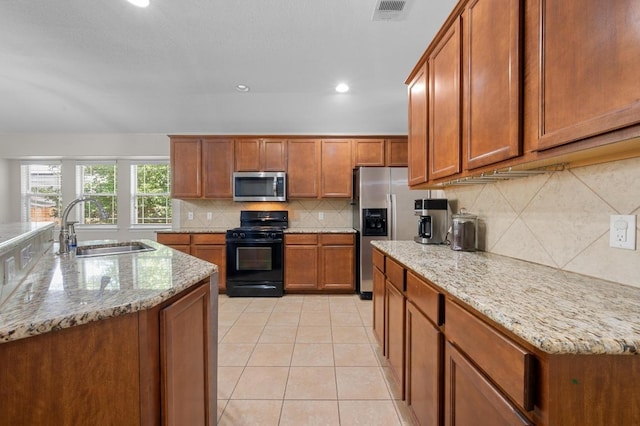 1286 Talley Loop, Buda, TX 78610 - kitchen featuring appliances with stainless steel finishes, a sink, brown cabinets, decorative backsplash, and recessed lighting