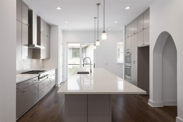 4703 Unity Cir Unit 284, Austin, TX 78731 - kitchen featuring a sink, gas stovetop, gray cabinets, wall chimney exhaust hood, and a center island with sink