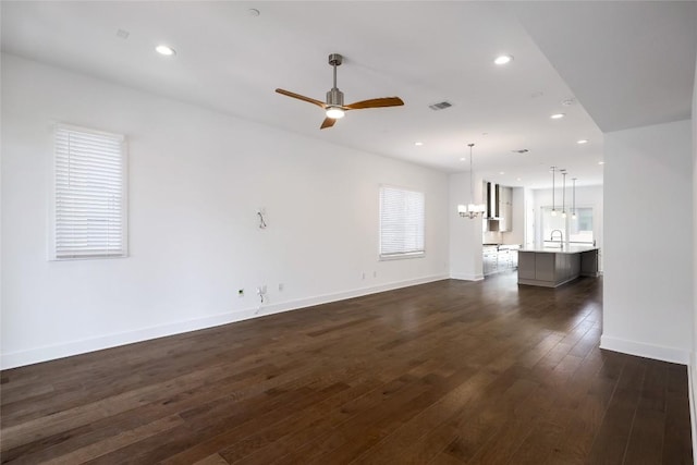 4703 Unity Cir Unit 284, Austin, TX 78731 - unfurnished living room featuring a sink, ceiling fan, a chandelier, recessed lighting, and dark wood-type flooring