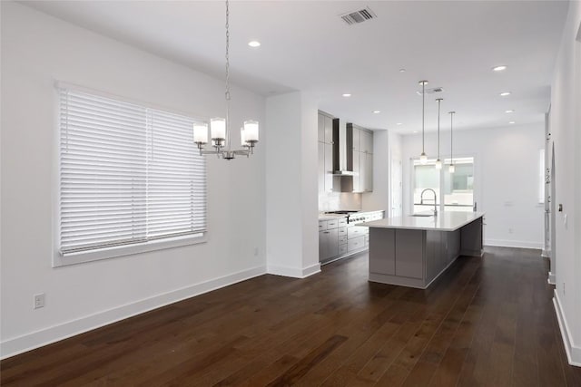 4703 Unity Cir Unit 284, Austin, TX 78731 - kitchen with wall chimney range hood, a sink, a chandelier, light countertops, and a kitchen island with sink