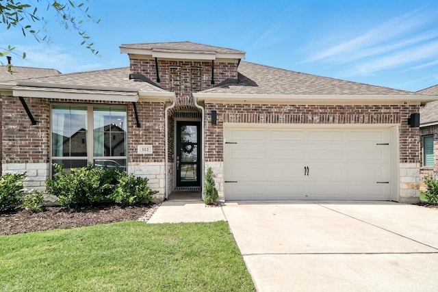 112 Rosemary Ct, Bastrop, TX 78602 - french country inspired facade with driveway, a shingled roof, an attached garage, brick siding, and stone siding