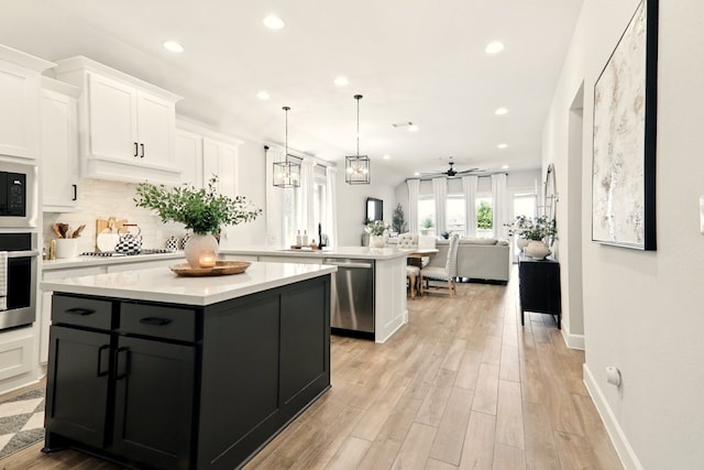 112 Rosemary Ct, Bastrop, TX 78602 - kitchen with stainless steel appliances, a center island, a peninsula, recessed lighting, and light countertops