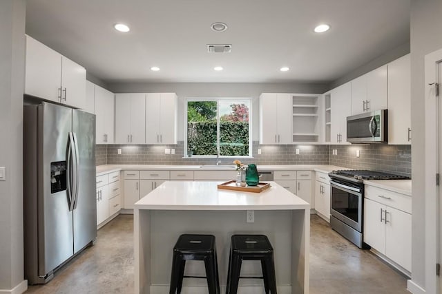 4020 Airport Blvd Unit 9, Austin, TX 78722 - kitchen featuring appliances with stainless steel finishes, concrete flooring, a sink, a kitchen breakfast bar, and recessed lighting