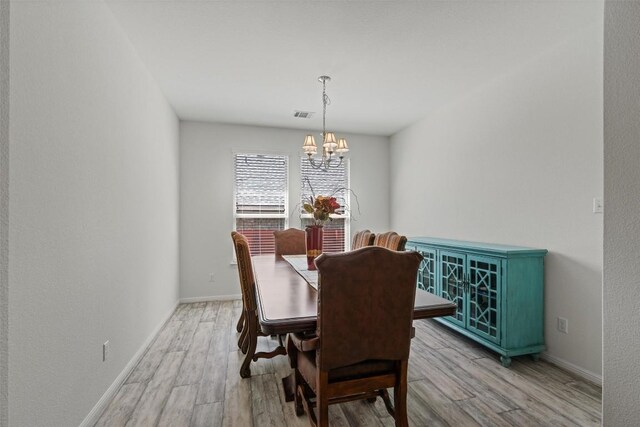 13708 Field Stream Ln, Manor, TX 78653 - dining area featuring a chandelier, light wood-type flooring, and baseboards