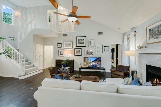 1704 Prairie Hen Cv, Austin, TX 78758 - living area with high vaulted ceiling, a stone fireplace, stairway, wood finished floors, and a ceiling fan