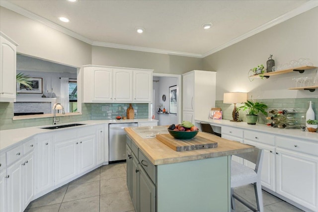 1704 Prairie Hen Cv, Austin, TX 78758 - kitchen featuring stainless steel dishwasher, decorative backsplash, a center island, crown molding, and white cabinetry