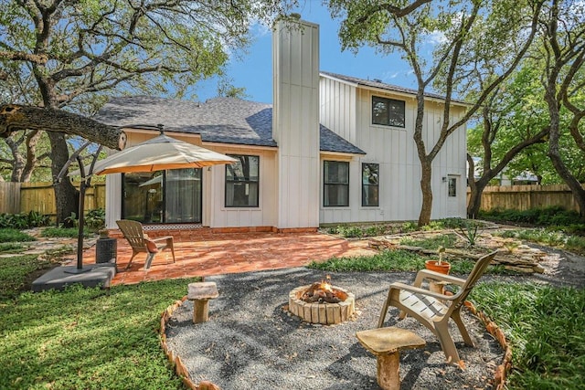 1704 Prairie Hen Cv, Austin, TX 78758 - rear view of house with a patio, an outdoor fire pit, a chimney, and a shingled roof