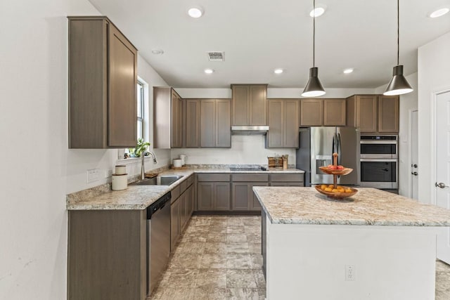 18517 Spotted Eagle Ln, Elgin, TX 78621 - kitchen featuring appliances with stainless steel finishes, under cabinet range hood, a center island, hanging light fixtures, and recessed lighting