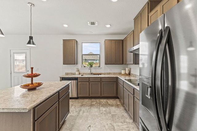 18517 Spotted Eagle Ln, Elgin, TX 78621 - kitchen featuring refrigerator with ice dispenser, stainless steel dishwasher, black electric cooktop, light countertops, and hanging light fixtures