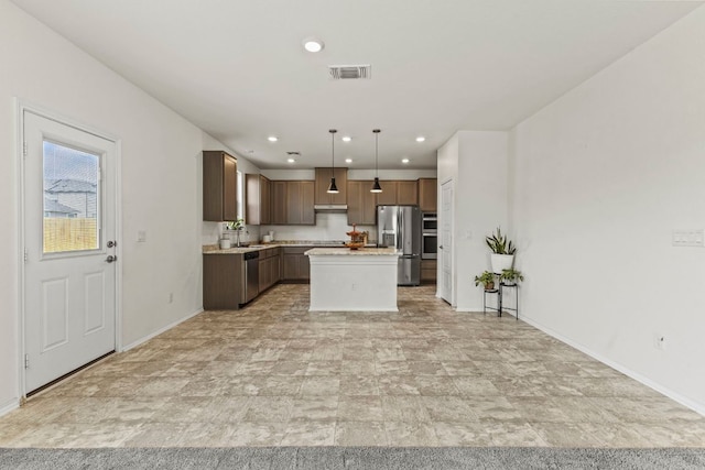 18517 Spotted Eagle Ln, Elgin, TX 78621 - kitchen with appliances with stainless steel finishes, light countertops, a kitchen island, recessed lighting, and under cabinet range hood