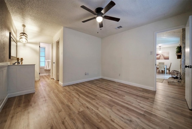 615 Twin Oak Trl, Cedar Park, TX 78613 - unfurnished living room featuring a ceiling fan, a textured ceiling, and wood finished floors