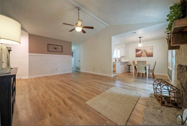 615 Twin Oak Trl, Cedar Park, TX 78613 - living area featuring a ceiling fan, light wood finished floors, lofted ceiling, and wainscoting