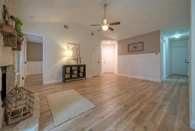 615 Twin Oak Trl, Cedar Park, TX 78613 - unfurnished living room with a ceiling fan, wainscoting, a fireplace, and light wood-type flooring
