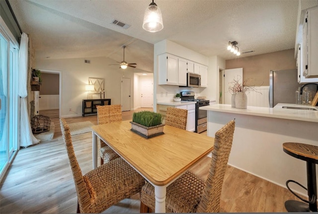 615 Twin Oak Trl, Cedar Park, TX 78613 - dining area with light wood finished floors, a ceiling fan, lofted ceiling, and a textured ceiling