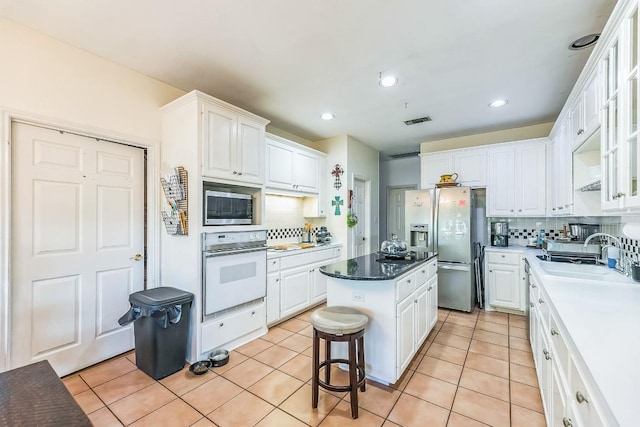 909 Oak Meadow Dr, Dripping Springs, TX 78620 - kitchen with appliances with stainless steel finishes, a sink, backsplash, white cabinets, and recessed lighting