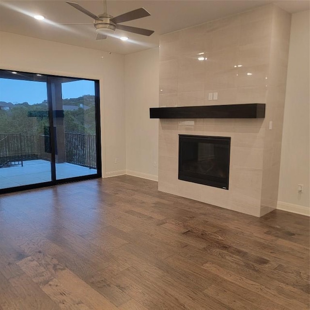 6833 Destination Way, Lago Vista, TX 78645 - unfurnished living room with baseboards, wood finished floors, ceiling fan, and a fireplace