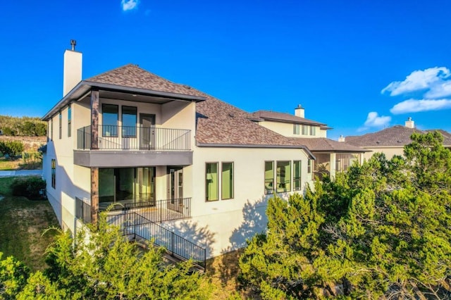 6833 Destination Way, Lago Vista, TX 78645 - rear view of property with a balcony, a chimney, stucco siding, and a shingled roof