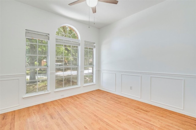14710 Montoro Dr, Austin, TX 78728 - unfurnished room with a ceiling fan, light wood-style floors, a decorative wall, and wainscoting