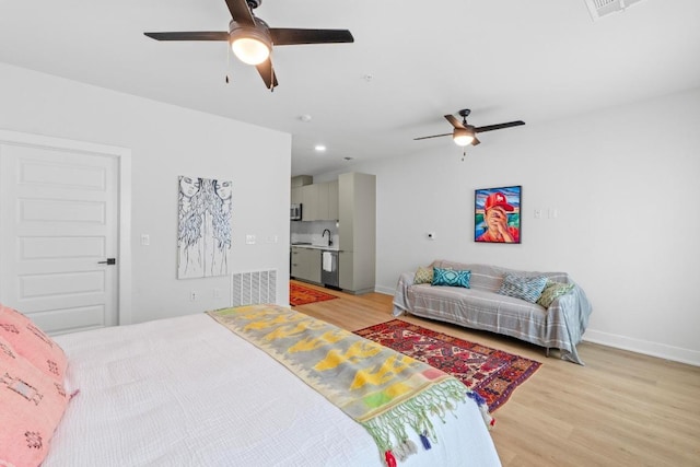 2500 Longview St Unit 112, Austin, TX 78705 - bedroom featuring light wood-style floors, a sink, baseboards, and a ceiling fan