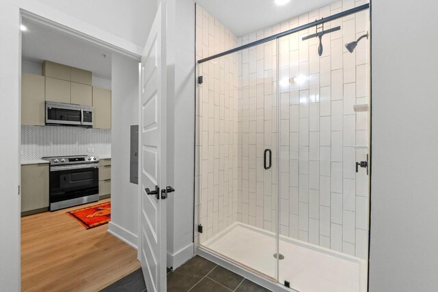 2500 Longview St Unit 112, Austin, TX 78705 - bathroom featuring a stall shower, backsplash, wood finished floors, and vanity