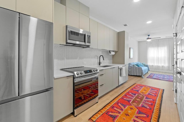 2500 Longview St Unit 112, Austin, TX 78705 - kitchen with stainless steel appliances, a sink, light countertops, decorative backsplash, and ceiling fan