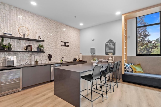 2500 Longview St Unit 112, Austin, TX 78705 - kitchen featuring wine cooler, a breakfast bar, light wood-style flooring, backsplash, and recessed lighting