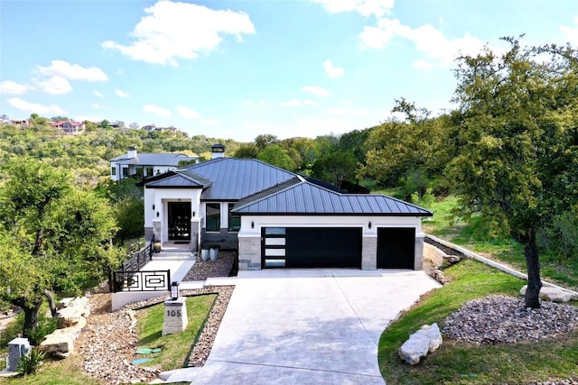 105 Golden Eagle, Horseshoe Bay, TX 78657 - contemporary house with a standing seam roof, concrete driveway, a garage, metal roof, and stone siding