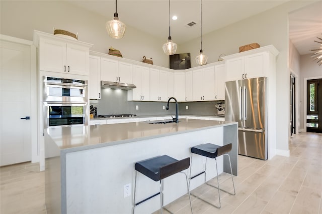 105 Golden Eagle, Horseshoe Bay, TX 78657 - kitchen featuring appliances with stainless steel finishes, a sink, tasteful backsplash, light countertops, and white cabinetry