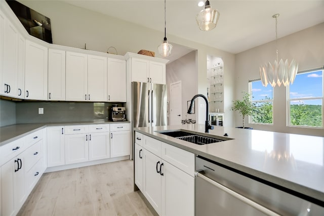 105 Golden Eagle, Horseshoe Bay, TX 78657 - kitchen with a sink, appliances with stainless steel finishes, decorative light fixtures, light countertops, and white cabinetry