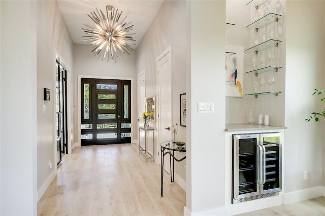 105 Golden Eagle, Horseshoe Bay, TX 78657 - entrance foyer featuring wine cooler, a chandelier, a bar, and baseboards