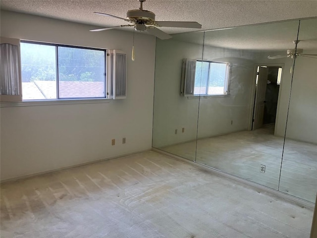 7201 Chimney Cors, Austin, TX 78731 - unfurnished bedroom with a textured ceiling, light colored carpet, and a ceiling fan