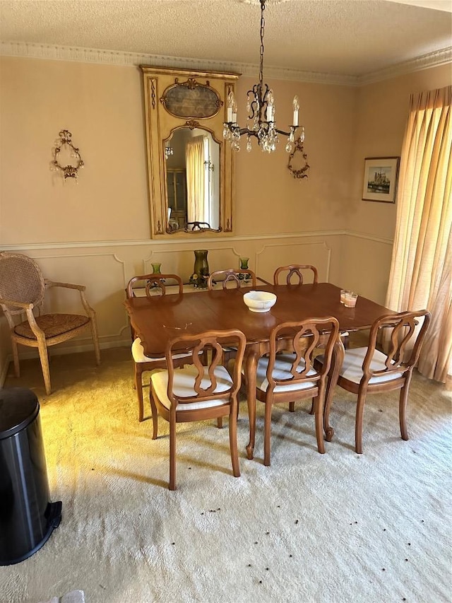 7201 Chimney Cors, Austin, TX 78731 - dining space with a textured ceiling, ornamental molding, a chandelier, a wainscoted wall, and light colored carpet