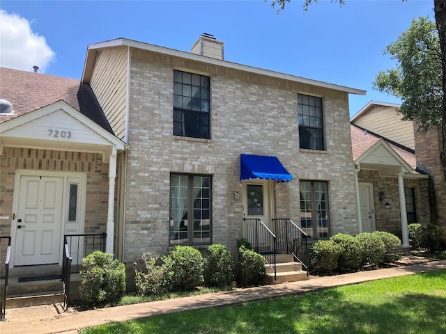 7201 Chimney Cors, Austin, TX 78731 - view of front facade with a chimney and brick siding
