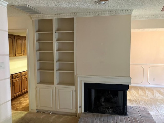 7201 Chimney Cors, Austin, TX 78731 - detailed view of a textured ceiling, built in features, a fireplace, and a wainscoted wall
