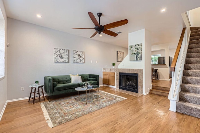 1411 Gracy Farms Ln Unit 113, Austin, TX 78758 - living room featuring stairs, a ceiling fan, light wood finished floors, recessed lighting, and a tiled fireplace