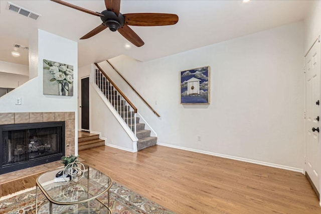 1411 Gracy Farms Ln Unit 113, Austin, TX 78758 - unfurnished living room with stairway, a ceiling fan, wood finished floors, a tile fireplace, and recessed lighting