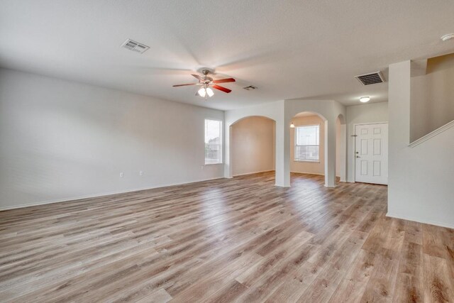 9104 China Rose Dr, Austin, TX 78724 - unfurnished room with arched walkways, ceiling fan, and light wood-style flooring