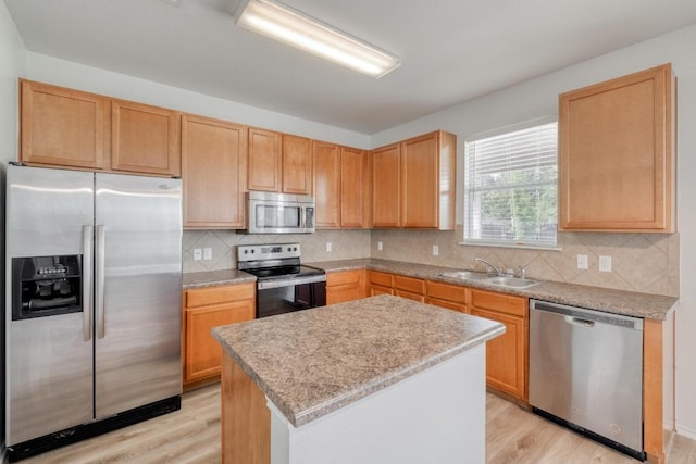 9104 China Rose Dr, Austin, TX 78724 - kitchen with appliances with stainless steel finishes, light wood finished floors, a kitchen island, and light countertops
