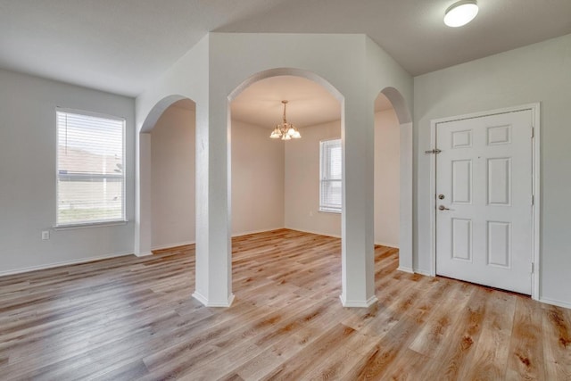 9104 China Rose Dr, Austin, TX 78724 - entryway with arched walkways, light wood-style floors, and a chandelier