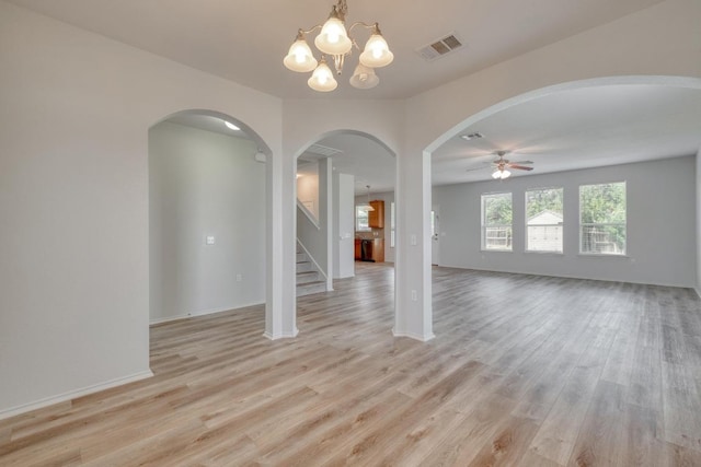 9104 China Rose Dr, Austin, TX 78724 - empty room with arched walkways, light wood-type flooring, a ceiling fan, stairway, and a chandelier