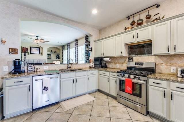 1433 Jenna Ln, Cedar Park, TX 78613 - kitchen with stainless steel appliances, a sink, decorative backsplash, arched walkways, and light stone countertops