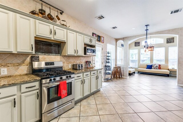 1433 Jenna Ln, Cedar Park, TX 78613 - kitchen with stainless steel appliances, arched walkways, decorative backsplash, and light tile patterned floors