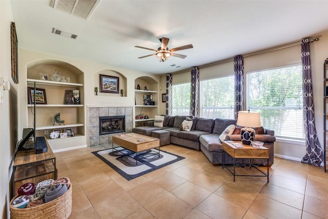 1433 Jenna Ln, Cedar Park, TX 78613 - living room with built in shelves, a ceiling fan, light tile patterned floors, baseboards, and a tile fireplace