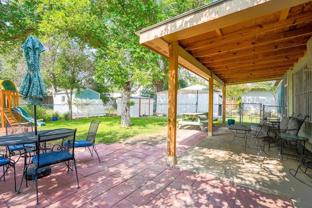 2607 Monticello Ct, San Antonio, TX 78223 - fenced backyard featuring a shed, outdoor dining area, a patio, and a playground