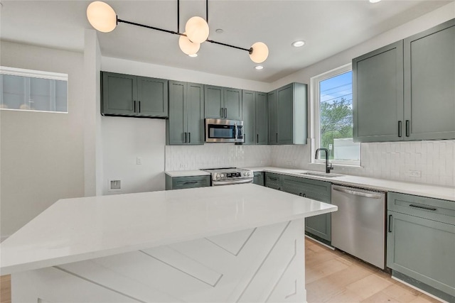 4127 E 12th St Unit 6, Austin, TX 78721 - kitchen with stainless steel appliances, a sink, tasteful backsplash, light wood-style floors, and recessed lighting