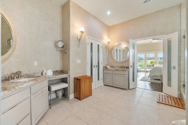 20503 Hoover Cv, Lago Vista, TX 78645 - ensuite bathroom featuring two vanities, a ceiling fan, tile patterned floors, french doors, and baseboards