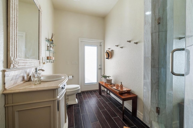 20503 Hoover Cv, Lago Vista, TX 78645 - bathroom featuring toilet, vanity, a shower stall, wood finished floors, and baseboards