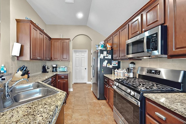 320 Atlanta Park Dr, Georgetown, TX 78628 - kitchen featuring appliances with stainless steel finishes, a sink, tasteful backsplash, vaulted ceiling, and light tile patterned floors